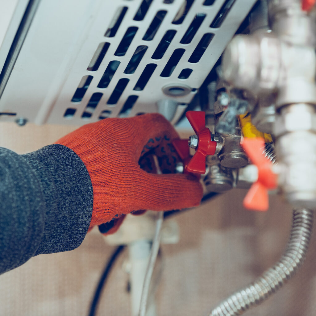 propane service technician working on a wall mounted heater