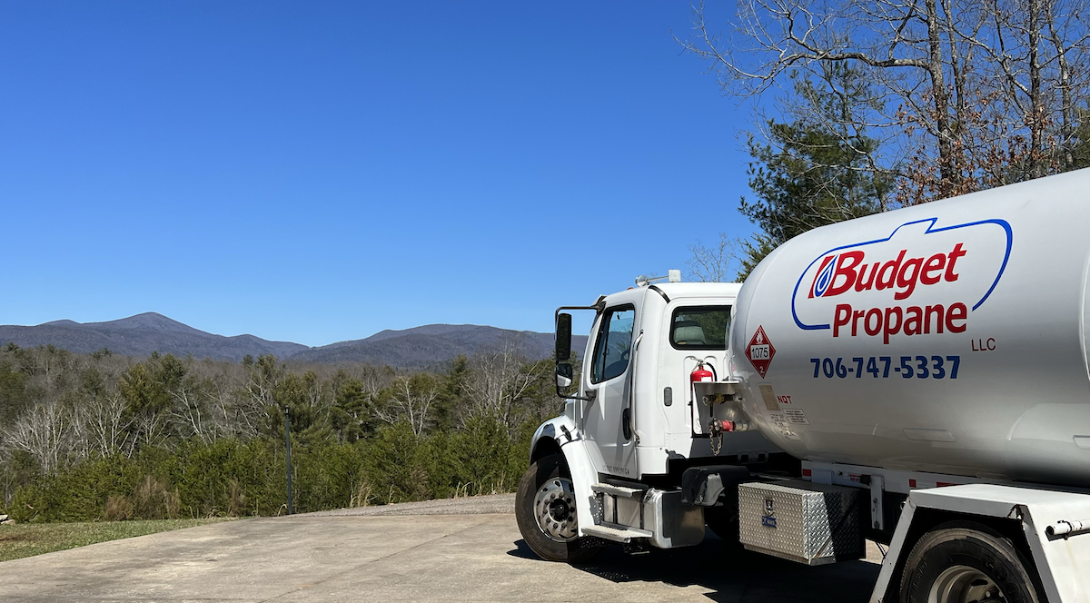 Budget Propane delivery truck in foreground with mountains in the background